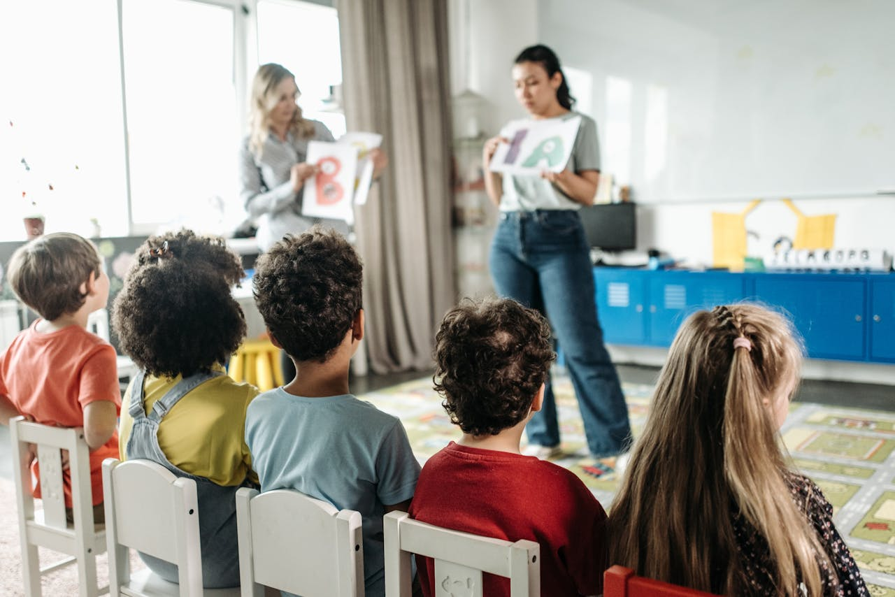 Children in a kindergarten classroom engaging with letters during a learning session.
